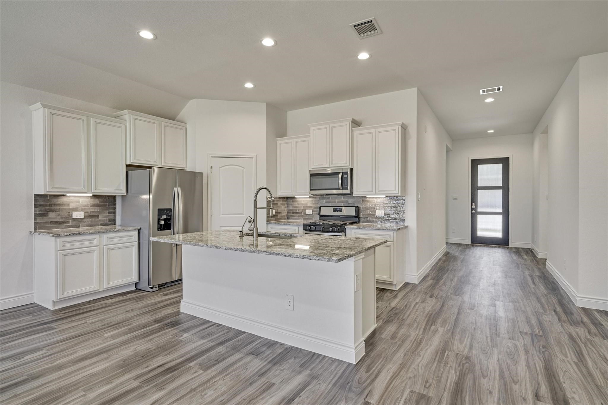 981 Youth Water Road Montgomery, TX 77316 - Photo 22 of 43 a kitchen with stainless steel appliances a refrigerator stove microwave and cabinets