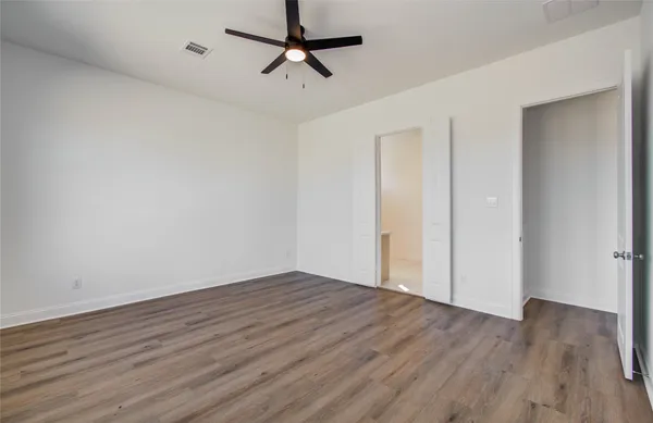 a view of room with hardwood floor and ceiling fan
