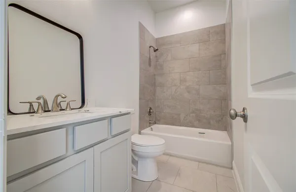 a bathroom with a granite countertop sink a toilet and shower