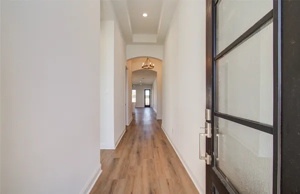 a view of a hallway with wooden floor and staircase