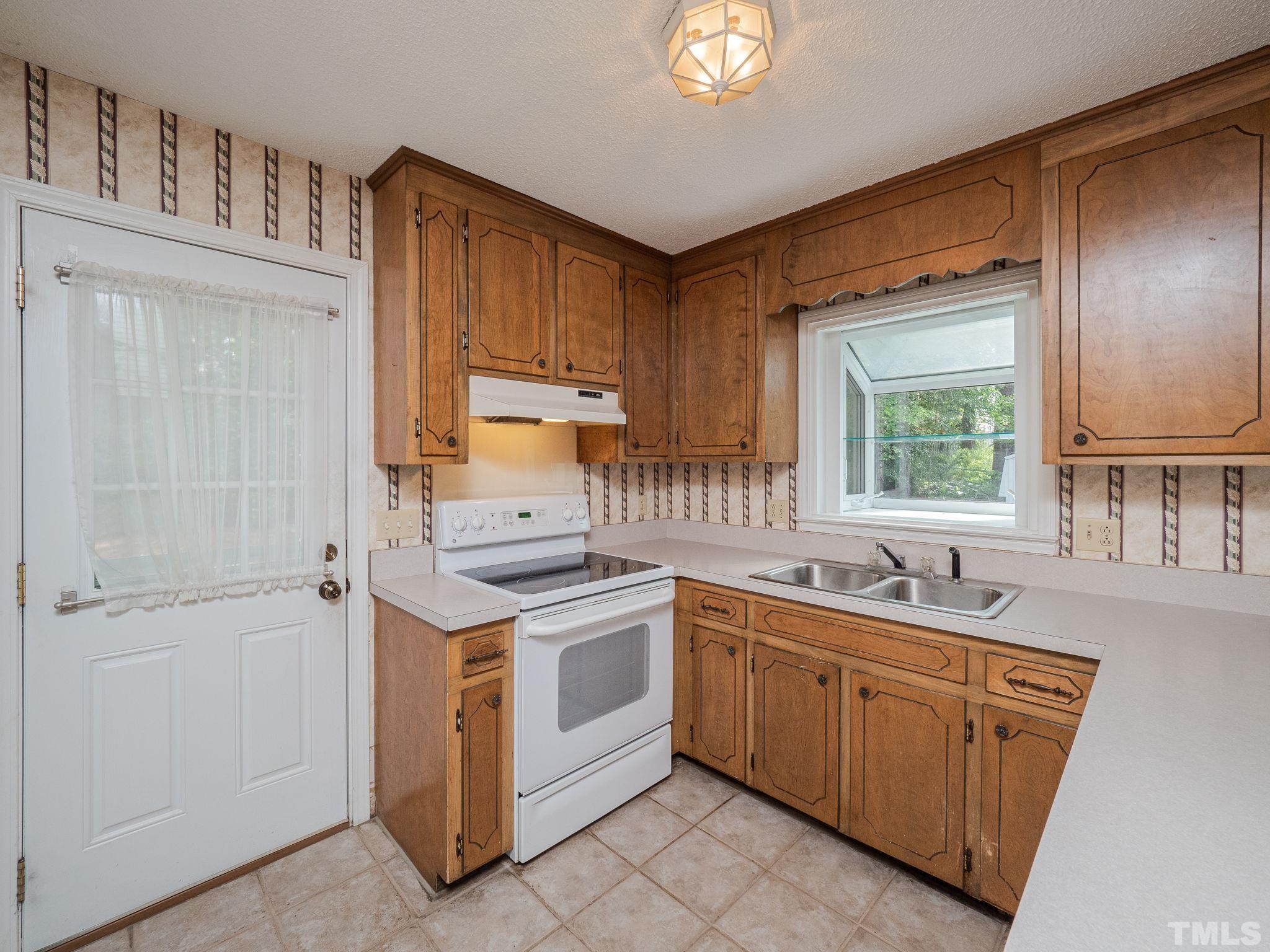 4504 Waterbury Road Raleigh, NC 27604 - Photo 25 of 38 a kitchen with a sink stove and cabinets