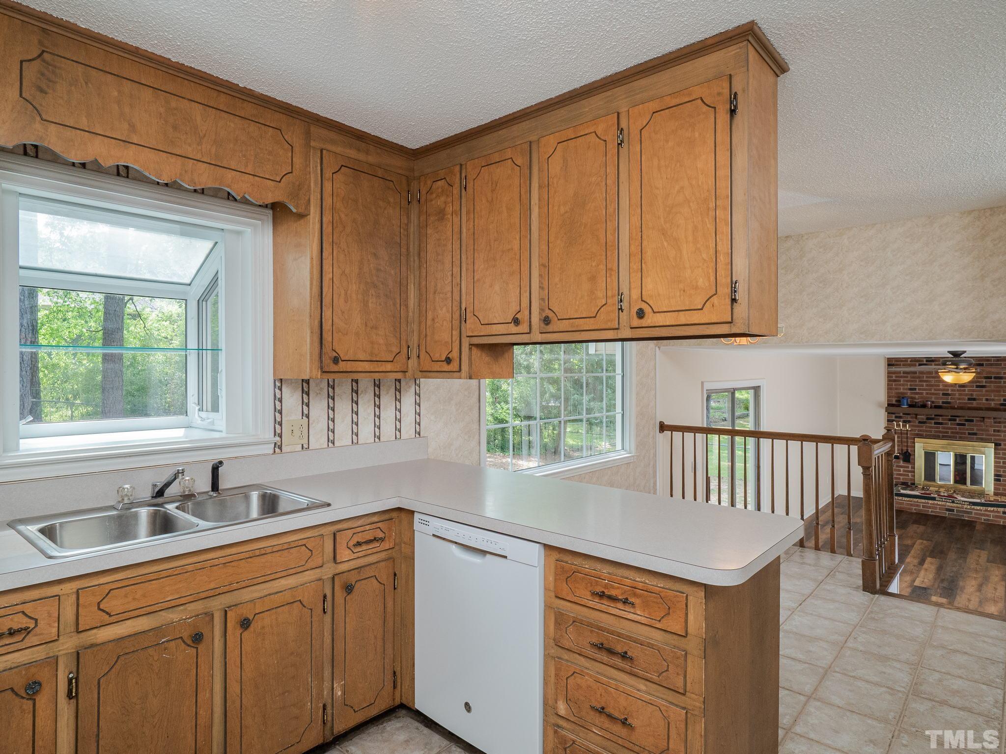 4504 Waterbury Road Raleigh, NC 27604 - Photo 28 of 38 a kitchen with stainless steel appliances granite countertop a sink and dishwasher cabinets with wooden floor
