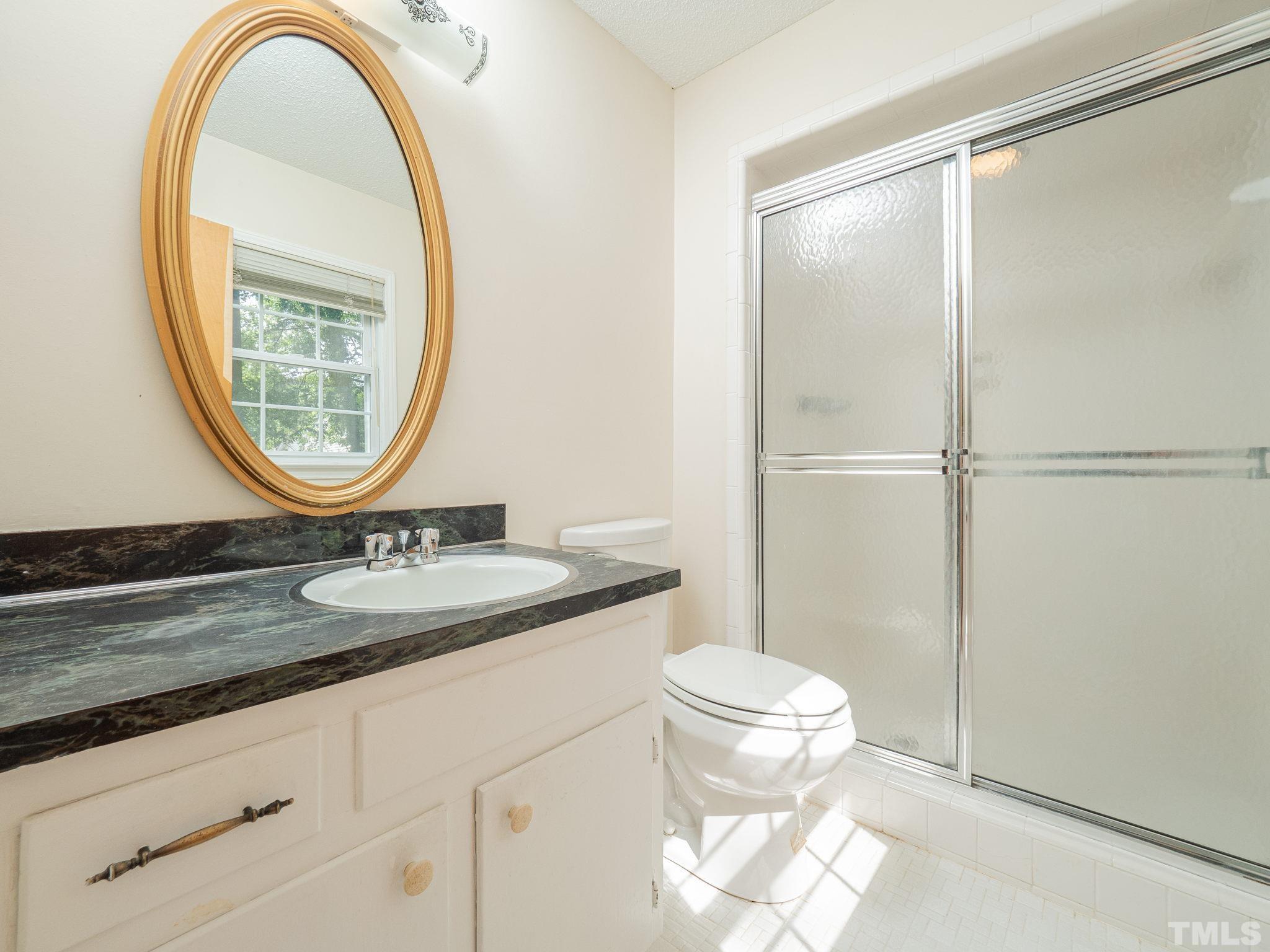4504 Waterbury Road Raleigh, NC 27604 - Photo 36 of 38 a bathroom with a granite countertop sink mirror vanity and toilet