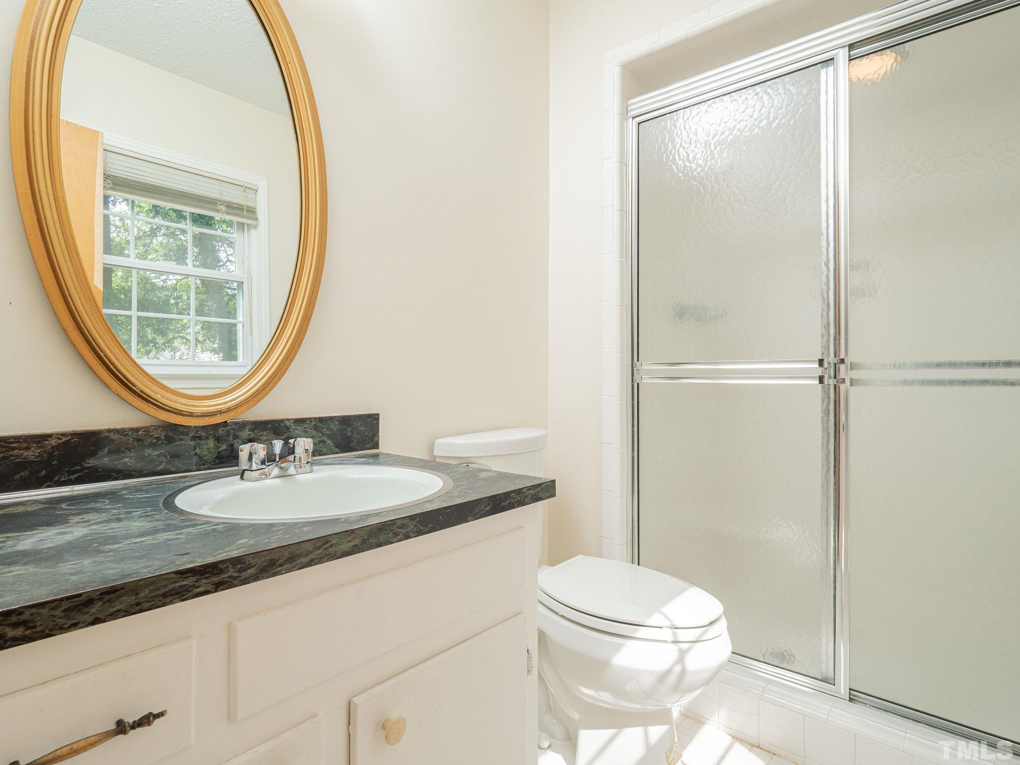 4504 Waterbury Road Raleigh, NC 27604 - Photo 37 of 38 a bathroom with a sink a toilet and a mirror