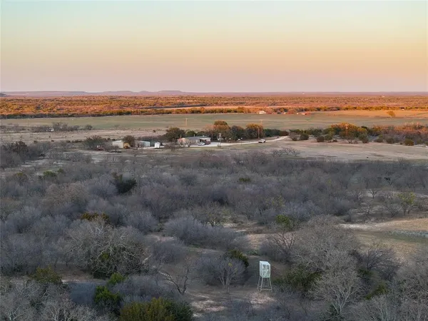 an aerial view of house with yard and mountain view in back