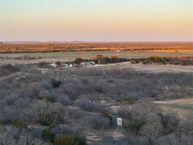 an aerial view of house with yard and mountain view in back