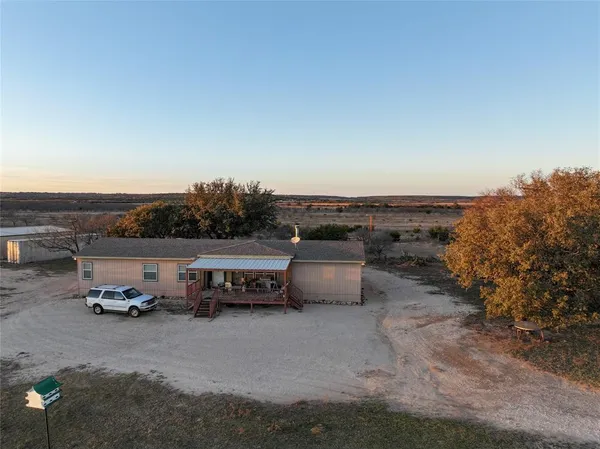 an aerial view of a houses with outdoor space and trees