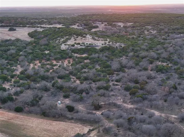 an aerial view of residential houses with outdoor space and ocean view