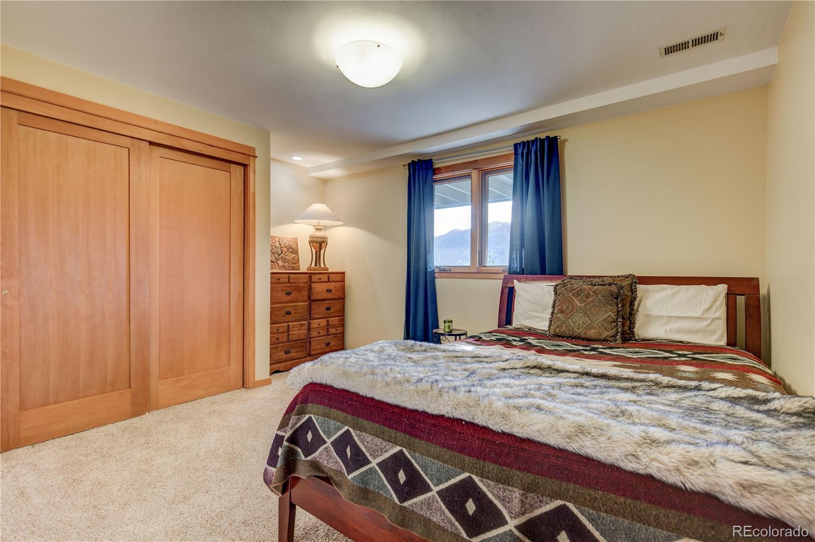 136 Elk Ridge Lane Boulder, CO 80302 - Photo 17 of 27 a bedroom with a large bed and a chandelier