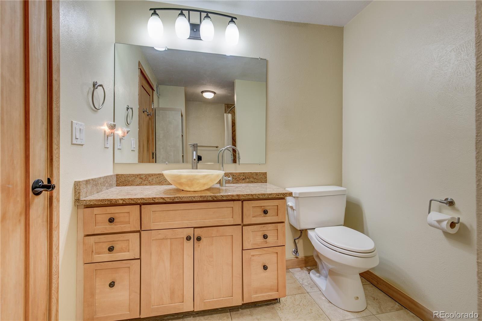 136 Elk Ridge Lane Boulder, CO 80302 - Photo 18 of 27 a bathroom with a granite countertop toilet sink and mirror