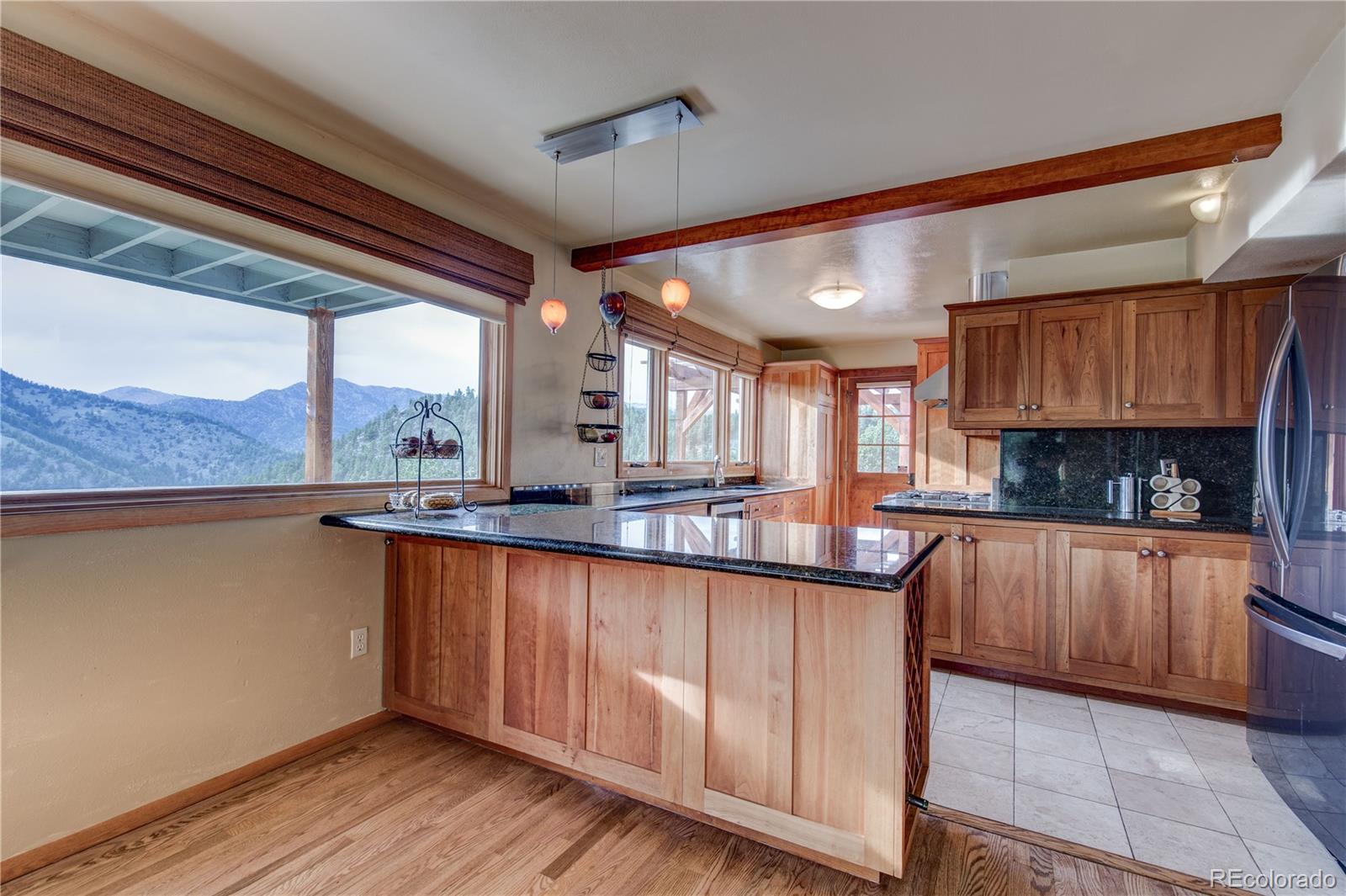 136 Elk Ridge Lane Boulder, CO 80302 - Photo 5 of 27 a kitchen with granite countertop wooden cabinets a sink and dishwasher a stove with wooden floor