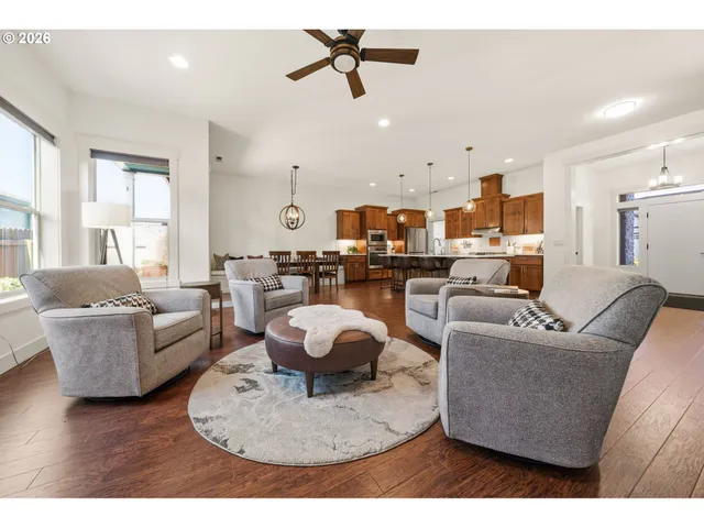 a living room with furniture kitchen view and a chandelier