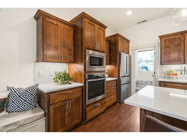 a kitchen with stainless steel appliances kitchen island granite countertop a refrigerator and a stove top oven