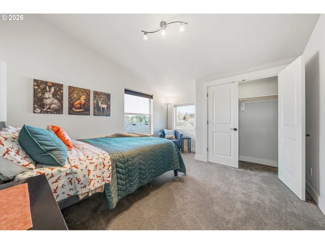 a bedroom with a bed and a painting on the wall