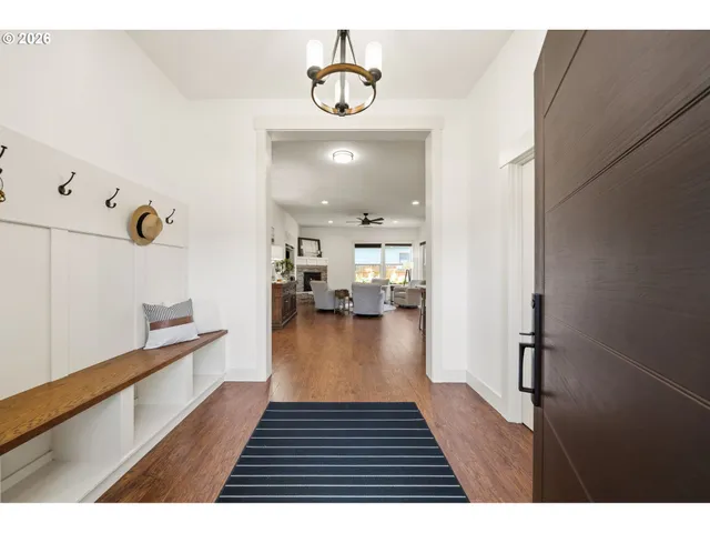 a hallway with a dining table wooden floor and a view of kitchen