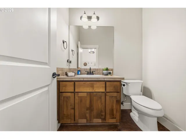 a bathroom with a sink vanity mirror and toilet