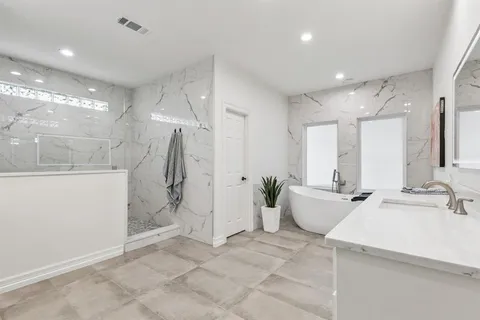 a bathroom with a double vanity sink mirror and shower