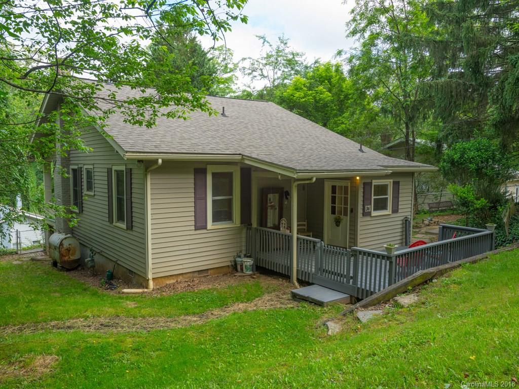 36 Sayles Road Asheville, NC 28803 - Photo 19 of 26 a backyard of a house with lawn chairs plants and tree