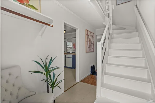 a view of staircase with white walls and a window