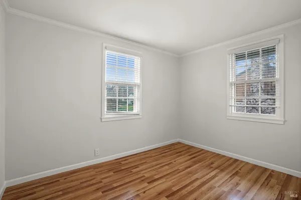 a view of a room with wooden floor and windows