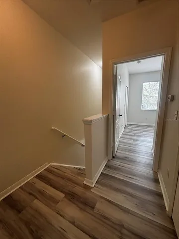 a view of a hallway with wooden floor