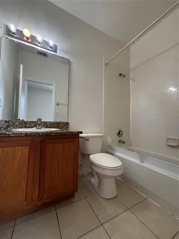 a bathroom with a toilet a sink a mirror and bathtub