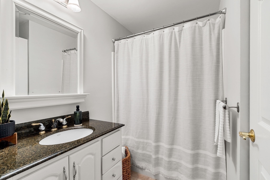 19 Broad Street, Unit 203 Merrimac, MA 01860 - Photo 16 of 22 a bathroom with a granite countertop sink and a mirror