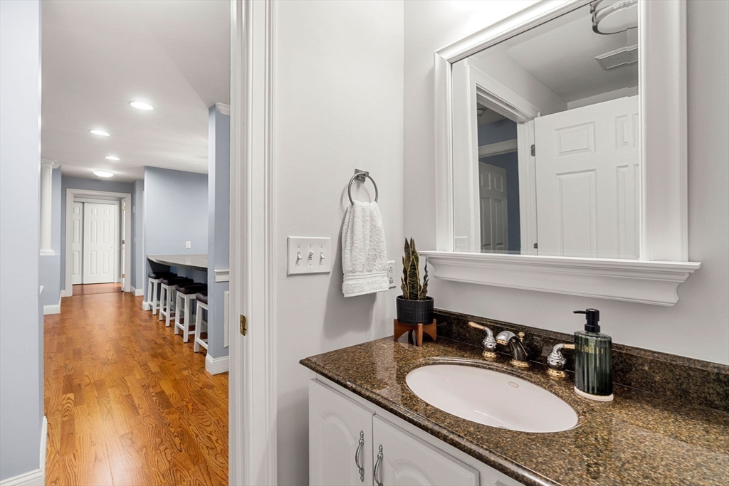 19 Broad Street, Unit 203 Merrimac, MA 01860 - Photo 17 of 22 a bathroom with a granite countertop sink and a mirror