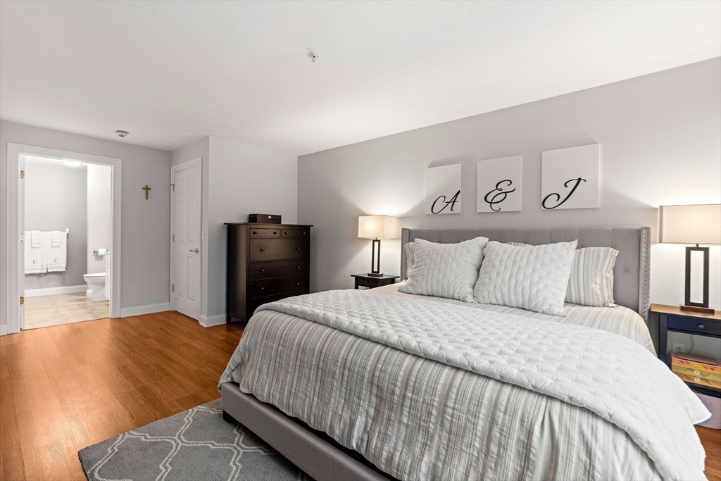 19 Broad Street, Unit 203 Merrimac, MA 01860 - Photo 10 of 22 a bedroom with a bed and wooden floor