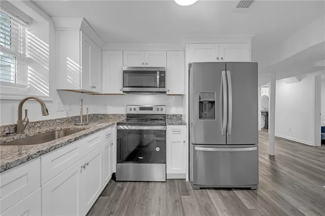 a kitchen with stainless steel appliances a refrigerator sink and microwave