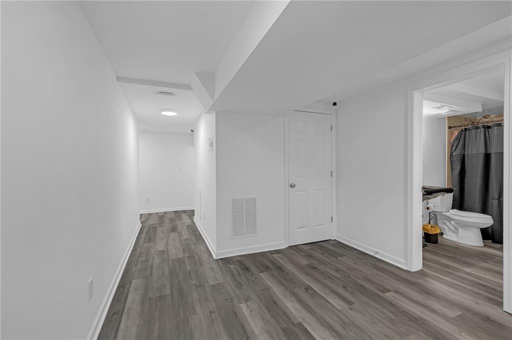 344 East Rhinehill Road Southeast Atlanta, GA 30315 - Photo 22 of 29 a view of a hallway with wooden floor and a bathroom
