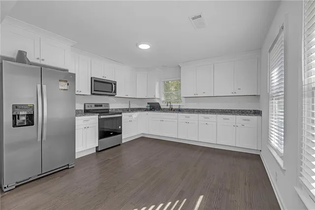 a kitchen with white cabinets and stainless steel appliances