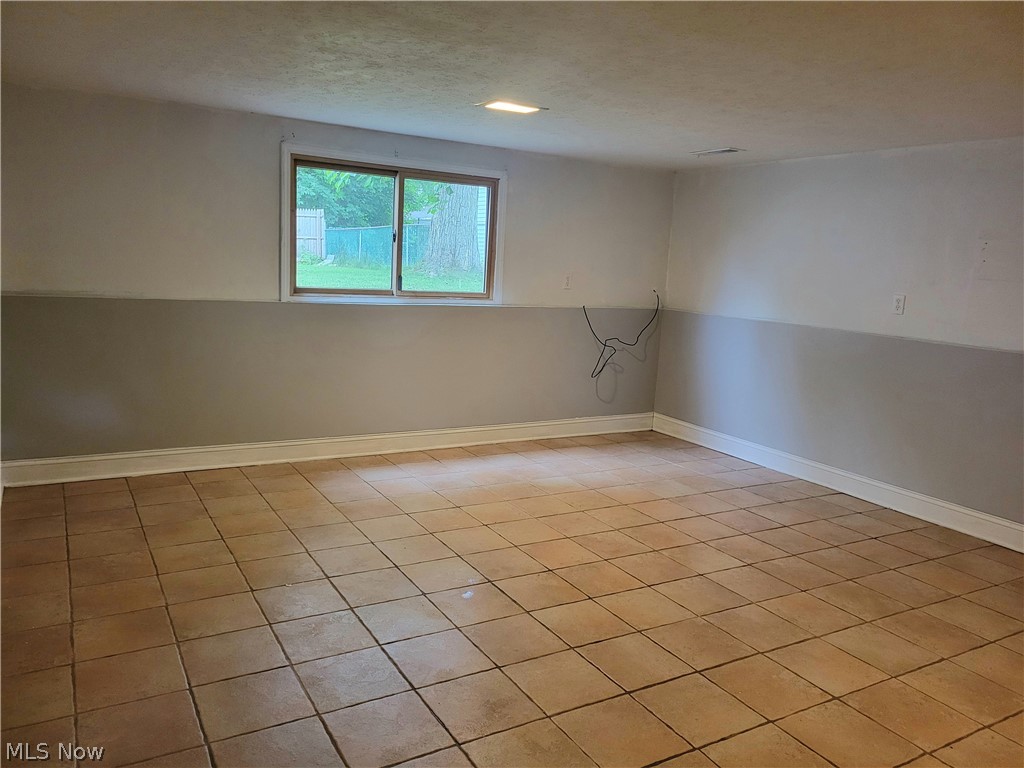 4895 Lear Nagle Road North Ridgeville, OH 44039 - Photo 10 of 27 Empty room featuring a textured ceiling and light tile floors
