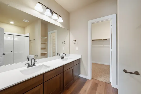 a bathroom with a double vanity sink a mirror and a shower