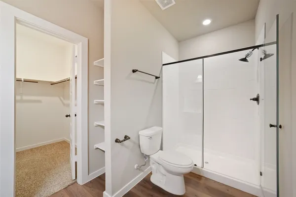 a bathroom with a granite countertop toilet a sink and shower