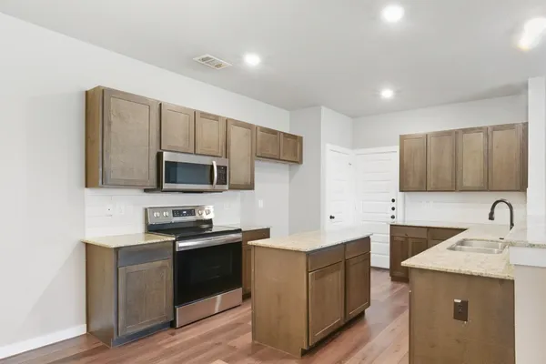 a kitchen with a sink stove top oven and refrigerator