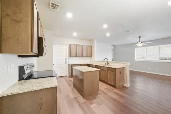 a large kitchen with stainless steel appliances granite countertop a sink stove and refrigerator