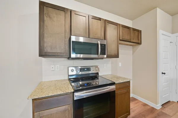 a kitchen with stainless steel appliances wooden cabinets and a stove