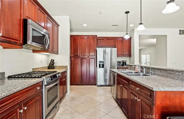 a large kitchen with stainless steel appliances granite countertop a stove and a refrigerator