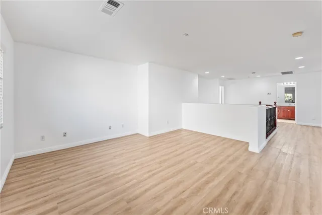 an empty room with wooden floor and window
