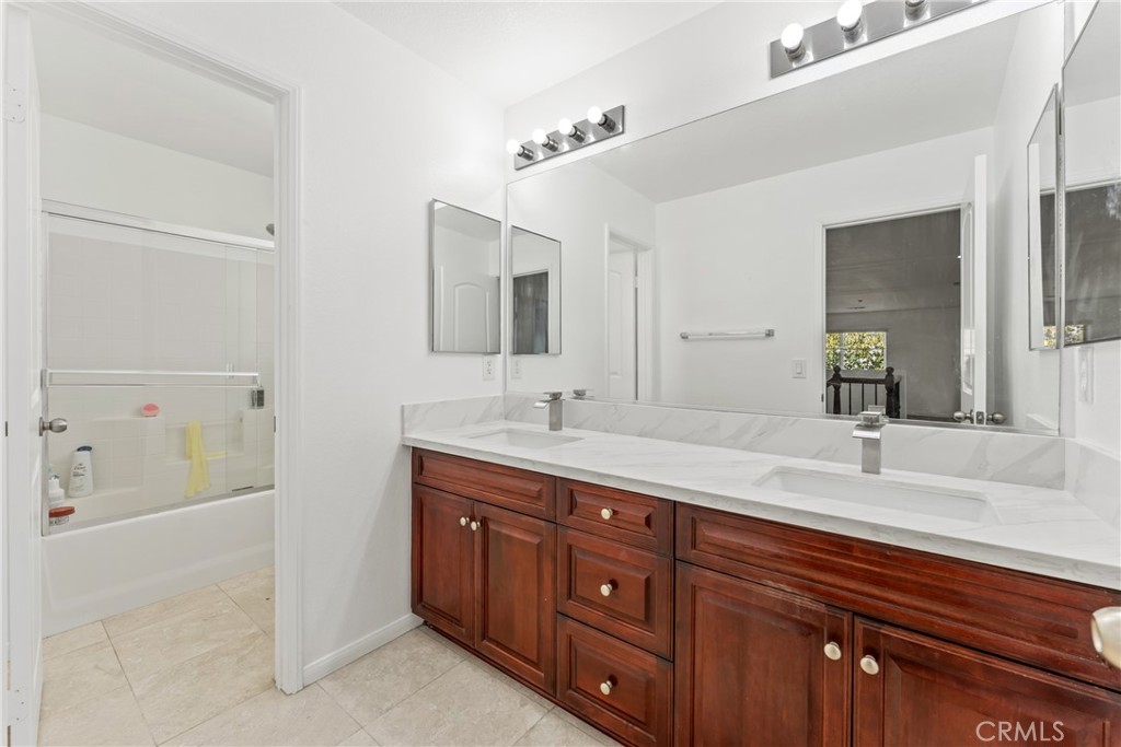 4816 Gregory Road Riverside, CA 92501 - Photo 33 of 55 a bathroom with a granite countertop double vanity sink and mirror