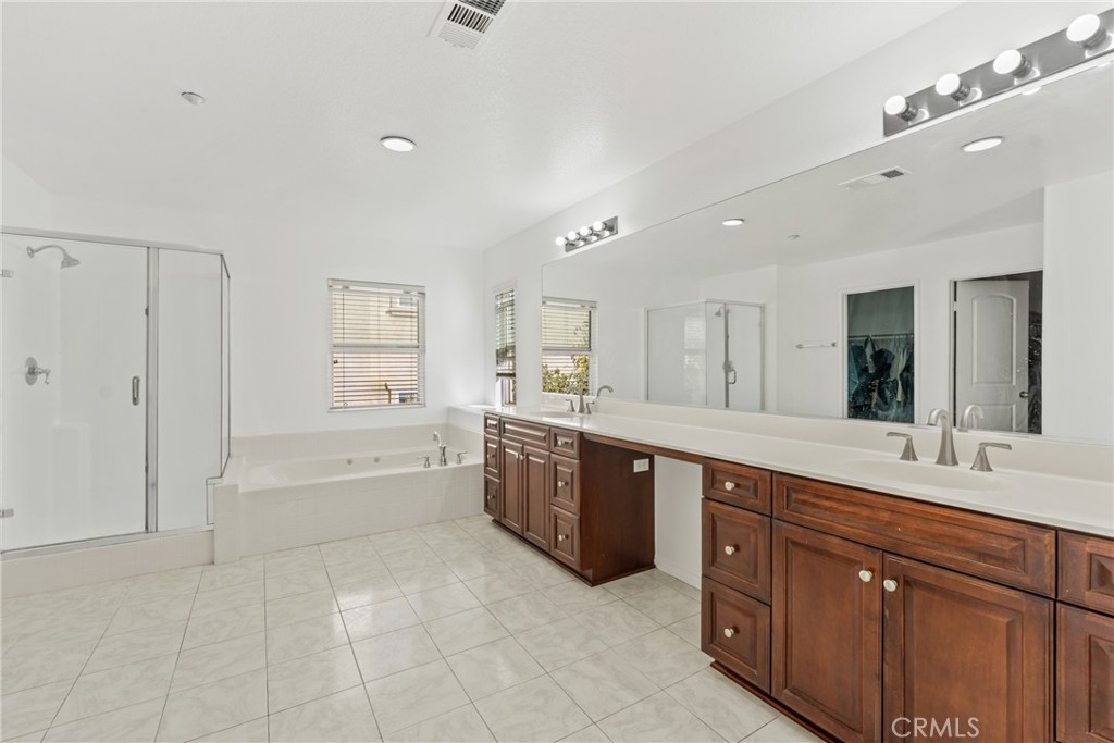 4816 Gregory Road Riverside, CA 92501 - Photo 38 of 55 a large bathroom with a granite countertop double vanity sink a mirror and a bathtub