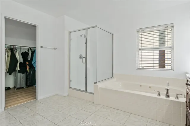 a spacious bathroom with a tub sink and mirror