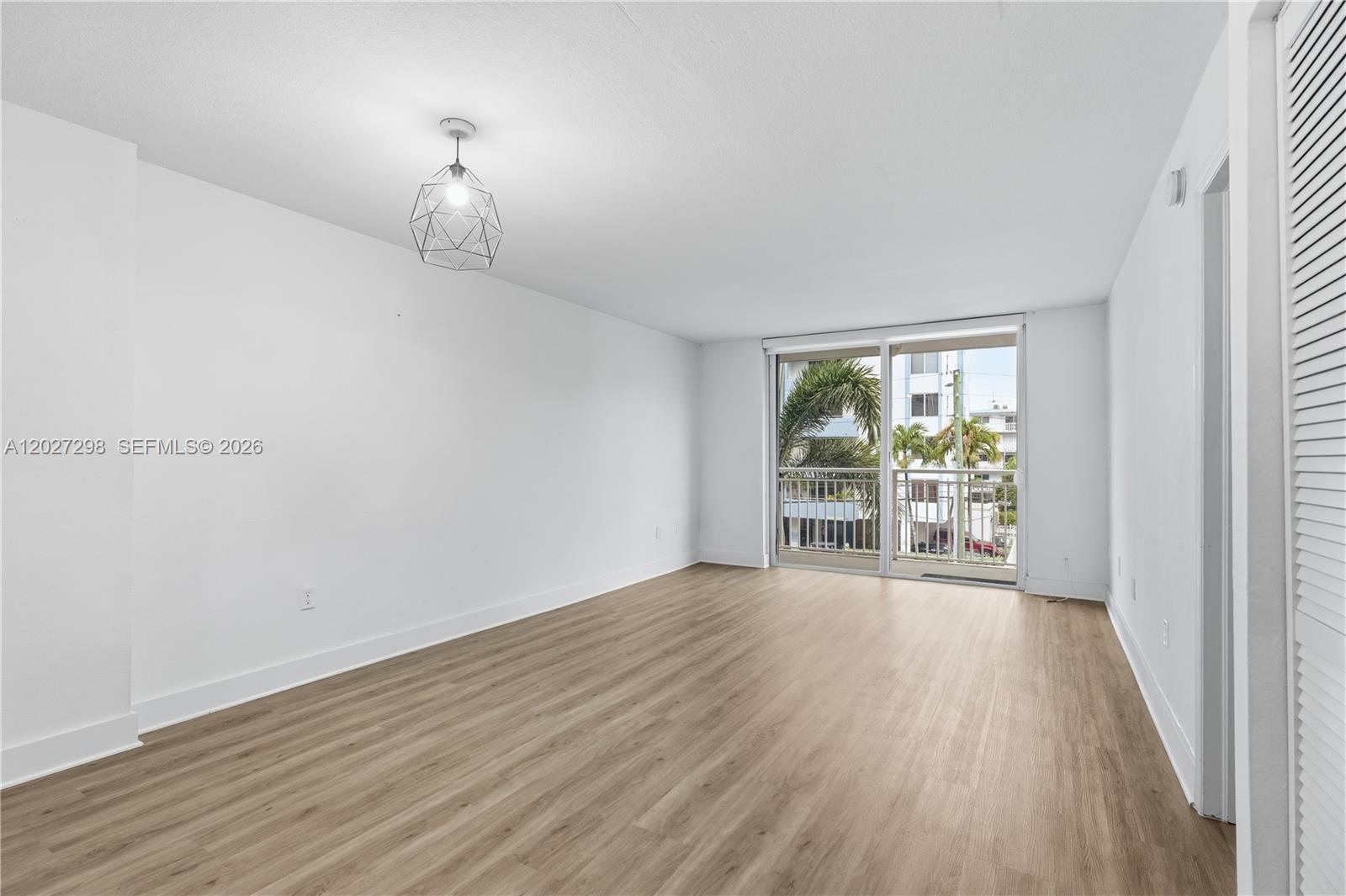 1665 Bay Road, Unit 322 Miami Beach, FL 33139 - Photo 7 of 24 a view of an empty room with wooden floor and a window