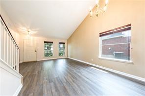 805 Chiselpoint Cove Round Rock, TX 78681 - Photo 14 of 38 Unfurnished living room featuring dark wood finished floors and vaulted ceiling