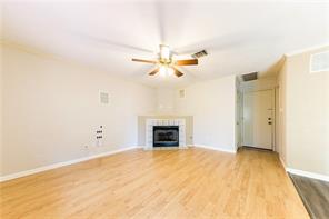 805 Chiselpoint Cove Round Rock, TX 78681 - Photo 15 of 38 Unfurnished living room featuring ceiling fan, light wood-style flooring, and a tiled fireplace