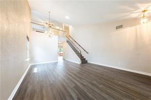 805 Chiselpoint Cove Round Rock, TX 78681 - Photo 18 of 38 Unfurnished living room featuring dark wood-type flooring and baseboards