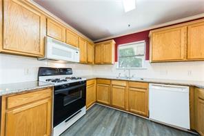 805 Chiselpoint Cove Round Rock, TX 78681 - Photo 27 of 38 Kitchen with white appliances, light countertops, and dark wood-type flooring