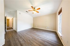 805 Chiselpoint Cove Round Rock, TX 78681 - Photo 6 of 38 Empty room featuring ceiling fan, dark wood-type flooring, and vaulted ceiling