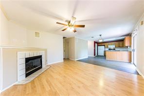 805 Chiselpoint Cove Round Rock, TX 78681 - Photo 7 of 38 Unfurnished living room featuring ceiling fan, light wood finished floors, and a fireplace